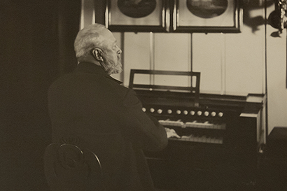 King Oskar II sits at his organ